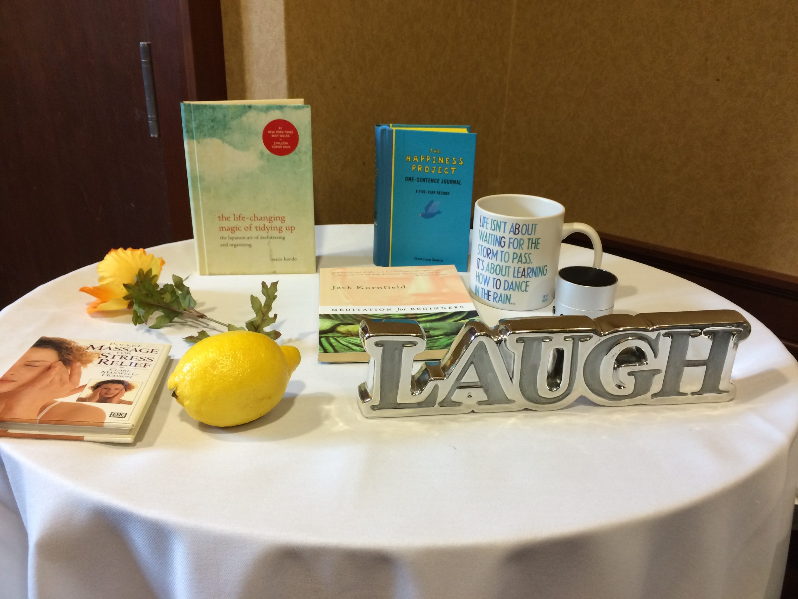 table display with books, flowers, a mug and a sign that says laugh