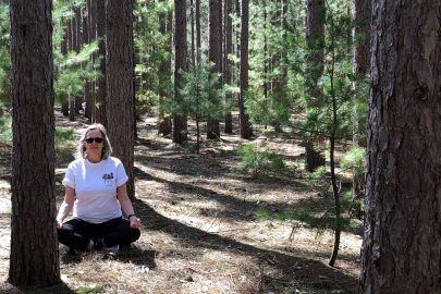 woman meditating surrounded by trees